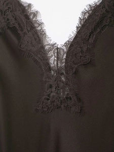 Close-up of elegant V-neckline with delicate eyelash lace trim on satin fabric dress