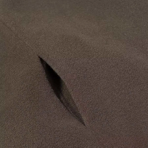 Dettaglio macro del tessuto in lana marrone scuro con fessura diagonale della tasca