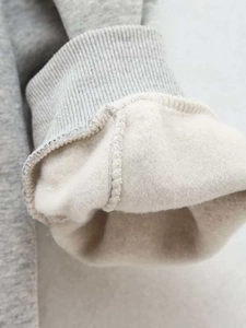 Detailed close-up of ribbed cuffs and soft fleece lining on a gray sweatshirt