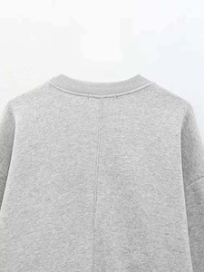 Detail of the grey crewneck sweatshirt featuring ribbed collar and vertical back seam stitching