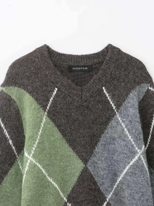 Detail shot of the V-neck knit sweater featuring grey argyle patterns and mohair texture