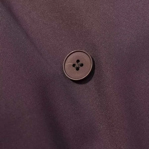 Vue macro détaillée de la texture du tissu sergé et des boutons assortis d'un trench-coat