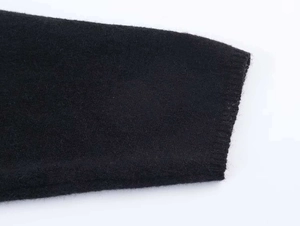 Close-up of black knitted sweater cuff featuring soft texture and ribbed edge detailing