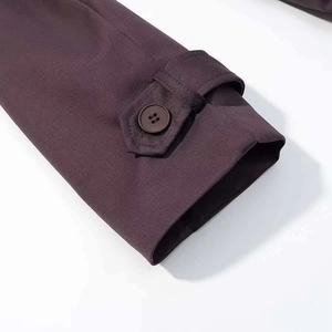 Vue détaillée du poignet du trench-coat prune avec bride décorative et bouton