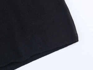 Detailed close-up of the delicate lace splicing and black knit texture on the garment