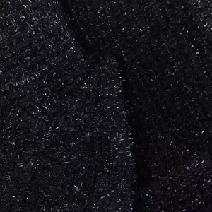 Vista macro di tessuto a maglia nero con dettagli in filo di lurex argento scintillante