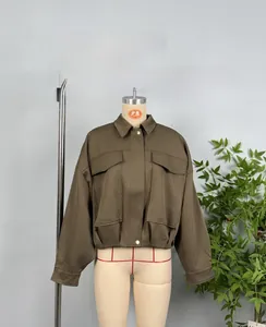 Detailed view of dark brown cropped bomber jacket with cargo pockets and gold buttons