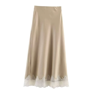 Dettaglio della gonna midi in raso champagne con elegante bordo in pizzo bianco all'orlo