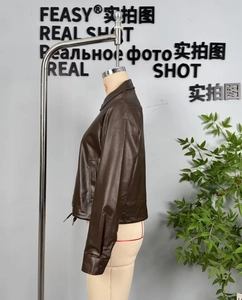 Close-up of brown faux leather jacket featuring classic collar and functional pockets
