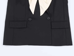 Detail of contrast lapel blazer with double-breasted buttons and flap pockets