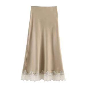 Dettaglio della gonna midi in raso color champagne con bordo in pizzo bianco sull'orlo