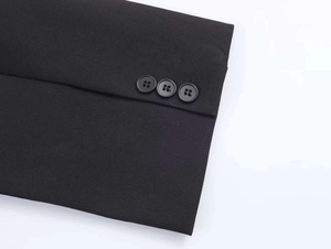 Detail of black blazer sleeve showing fine woven fabric and three neat round buttons