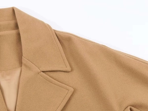 Detailed close-up of premium camel wool coat featuring fine stitching and thick fabric texture