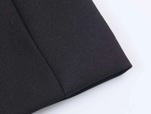 Close-up detail of high-density black twill fabric texture for elegant autumn blazer jacket