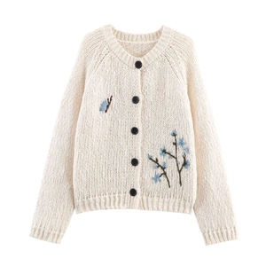 Chic beige knit cardigan featuring intricate blue floral embroidery and black buttons