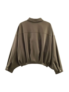 Detailed view of gathered pleated hem and drop shoulder of women's bomber jacket