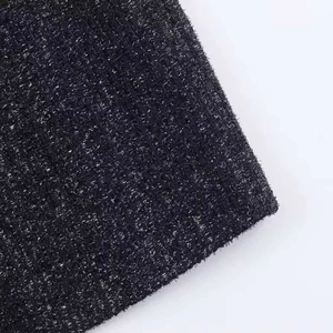 Dettaglio macro di tessuto nero con fili d'argento metallizzati e trama scintillante