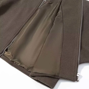 Dettaglio di giacca in lana marrone con fodera liscia e doppia cerniera in metallo