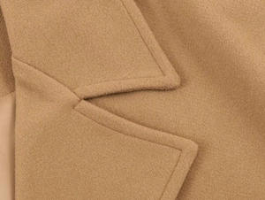 Macro shot of notch lapels and stitching details on a camel wool blend overcoat