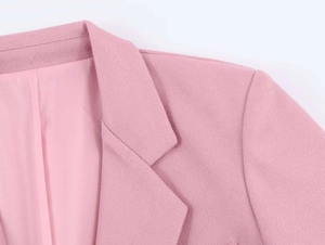 Detailed view of pink wool blazer lapel collar and soft texture with inner lining