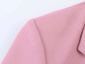 Detailed macro view of the premium pink wool fabric texture and shoulder stitching detail