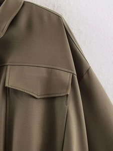Detailed close-up of collar and large flap pocket on olive green twill bomber jacket