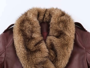 Detailed macro view of the dark red leather jacket featuring a plush brown faux fur collar