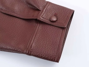 Detail of lychee pattern leather jacket cuff with stitched flap and matching button