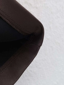 Gros plan détaillé d'une robe en maille marron foncé montrant les coutures de précision