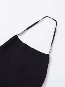 Detail view of black knit top featuring thin straps with elegant silver bead accents