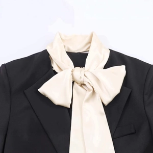 Minimalist black blazer with cream satin bow detail on neckline for elegant office wear