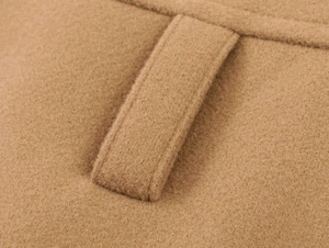 Detail shot of camel wool coat fabric texture and reinforced belt loop stitching