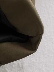Detail shot of olive green bomber jacket fabric with smooth inner lining and precise stitching