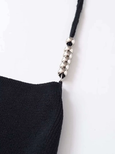 Detail of black knit top featuring silver sphere bead accents on delicate shoulder straps