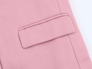 Close-up of pink wool blend fabric showing detailed stitching on a flap pocket