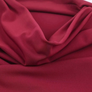 Detailed macro view of dark red knitted fabric texture with fine stitching edge