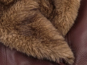 Detailed macro view of plush faux fur collar and textured leather jacket material