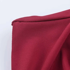 Macro view of dark red pleated fabric showing detailed knitted texture and stitching