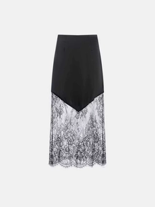 Detailed view of black satin fabric stitched with delicate floral lace on a midi skirt