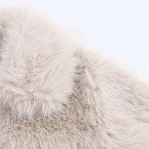 Gros plan sur une fausse fourrure gris clair montrant une texture douce et des poils longs