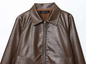 Detail view of brown faux leather jacket texture with INDEFEIR brand label