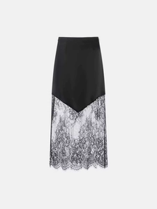 Detail of elegant black midi skirt featuring sleek satin and intricate floral lace patchwork