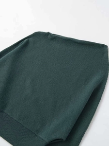 Detail of dark green knit sweater with boat neck and refined ribbed edge texture