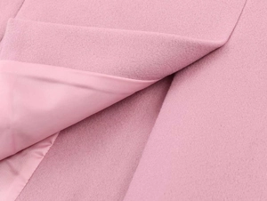 Detail view of pink wool coat fabric texture and premium smooth inner lining material