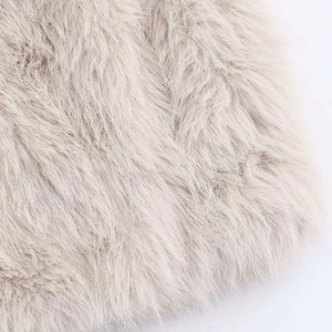 Gros plan sur la texture luxueuse en fausse fourrure beige clair pour manteau d'hiver