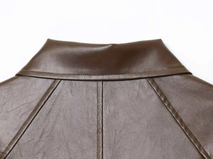 Detailed view of dark brown leather jacket collar and shoulder with precise stitching