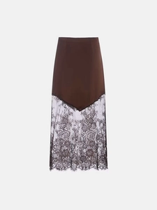Detailed close-up of brown satin skirt with black floral lace stitching and eyelash hem