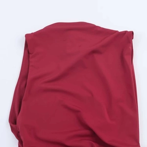 Detail of the crew neckline and sleeveless shoulder seams on dark red knitted dress