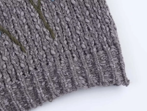 Close-up of gray ribbed knit sweater featuring detailed floral vine embroidery