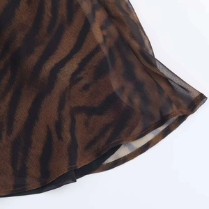Gros plan détaillé sur le tissu en mousseline à motif animal et l'ourlet soigné
